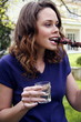 Woman eating souvlaki and drinking wine at a barbecue