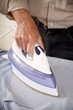 Mature man ironing shirt