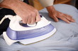 Mature man ironing shirt