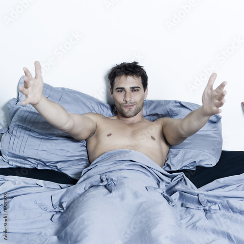 Photo: handsome man in a bed handsome man in a bed