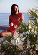 Young woman with drink on sea view balcony