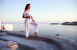 Woman in white outfit on terrace with a view
