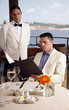 Man reading menu in restaurant;waiter waiting.