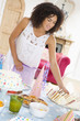 Woman at party getting sandwich from food table smiling