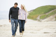 Photo: Couple walking at beach smiling Couple walking at beach smiling