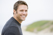 Photo: Man standing at beach smiling Man standing at beach smiling