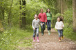 Family walking on path holding hands smiling Family walking on path holding hands smiling
