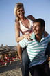 Photo: Mature adult couple piggyback on beach Mature adult couple piggyback on beach