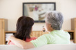 Photo: Couple watching television using remote control Couple watching television using remote control
