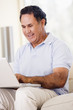 Man in living room with laptop smiling