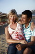 Photo: Mature adult couple sitting on beach Mature adult couple sitting on beach
