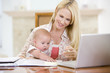 Photo: Mother and baby in dining room with laptop smiling Mother and baby in dining room with laptop smiling