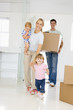 Photo: Family with box moving into new home smiling Family with box moving into new home smiling
