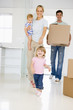 Photo: Family with box moving into new home smiling Family with box moving into new home smiling