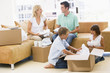 Photo: Family unpacking boxes in new home smiling Family unpacking boxes in new home smiling