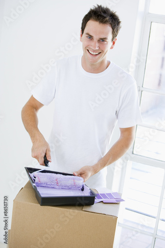 Man painting room in new home smiling Man painting room in new home smiling