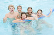 Foto: Five young friends in swimming pool playing and smiling Five young friends in swimming pool playing and smiling