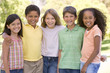 Five young friends standing outdoors smiling Five young friends standing outdoors smiling