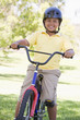 Photo: Young boy on bicycle outdoors smiling Young boy on bicycle outdoors smiling