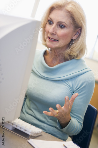Photo: Mature female student expressing frustration at computer Mature female student expressing frustration at computer