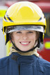 Portrait of a firefighter standing in front of a fire engine