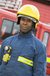 Portrait of a firefighter standing in front of a fire engine