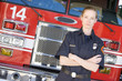 Portrait of a firefighter by a fire engine