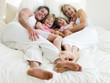 Family lying in bed smiling Family lying in bed smiling