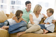 Family sitting in living room smiling