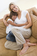 Woman and young girl sitting in living room smiling