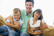 Man and two young children in living room smiling