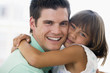 Man and young girl hugging and smiling