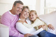 Family sitting in living room smiling