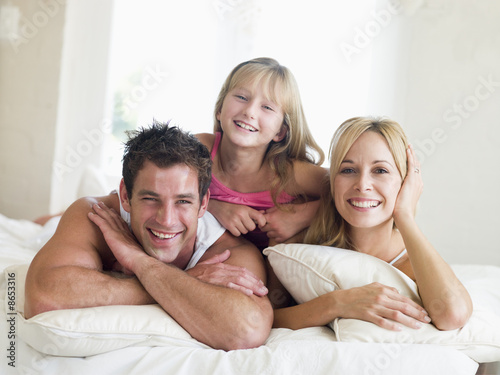Foto: Family lying in bed smiling Family lying in bed smiling