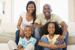 Family sitting in living room smiling