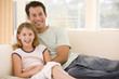 Man and young girl in living room smiling