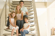 Family sitting on staircase smiling