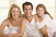 Family sitting in bed smiling