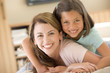 Photo: Woman and young girl in living room smiling Woman and young girl in living room smiling