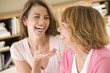 Photo: Two women sitting in living room talking and laughing Two women sitting in living room talking and laughing