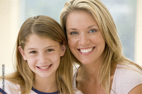 Photo: Woman and young girl in living room smiling Woman and young girl in living room smiling