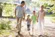 Family running outdoors holding hands and smiling