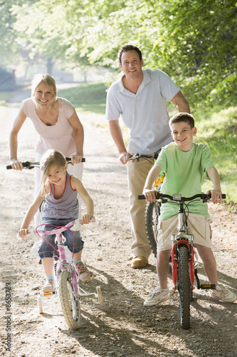 Family on bikes on path smiling