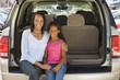 Photo: Woman with young girl sitting in back of van smiling Woman with young girl sitting in back of van smiling