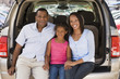 Photo: Family sitting in back of van smiling Family sitting in back of van smiling