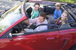 Foto: Family in convertible car smiling Family in convertible car smiling