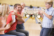 Foto: Family in bowling alley cheering and smiling Family in bowling alley cheering and smiling