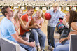 Foto: Family in bowling alley with two friends cheering and smiling Family in bowling alley with two friends cheering and smiling