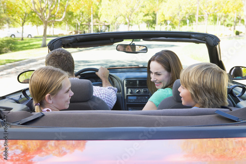 Foto: Family in convertible car smiling Family in convertible car smiling