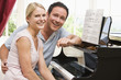 Couple sitting at piano smiling Couple sitting at piano smiling